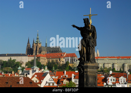 Statue de Jean le Baptiste sur le Pont Charles avec le Château de Prague en arrière-plan Banque D'Images