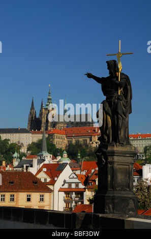 Statue de Jean le Baptiste sur le Pont Charles avec le Château de Prague en arrière-plan Banque D'Images