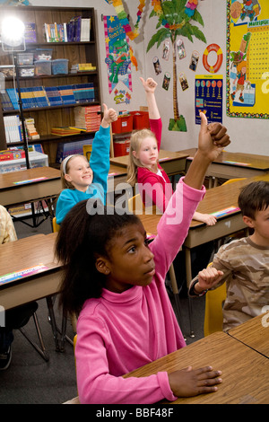 La diversité raciale inter raciales diversifiées multi culturel multiculturel étudiant 3ème année d'interracial 8 à 10 ans classe mains soulever avec enthousiasme Banque D'Images