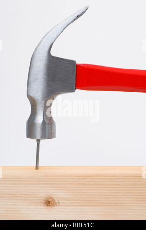 Hammer hitting un clou sur la tête en bois Banque D'Images