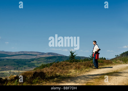 Lone Walker à la recherche à vue sur Kyle Of Sutherland en Écosse, pris près de bois à l'Balblair Bonar Bridge au printemps Banque D'Images