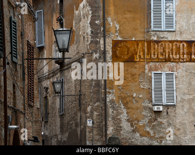 Signe de rouille à l'ancienne sur un mur de plâtre de déroulage à Sienne, Toscane, Italie Banque D'Images