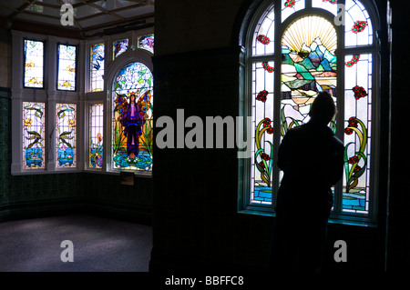 À la recherche d'un visiteur à un vitrail à l'intérieur de Victoria Baths, Manchester, Angleterre, RU Banque D'Images