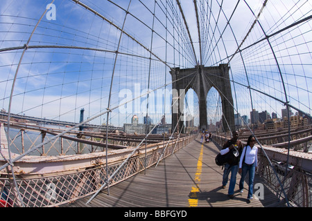 Les touristes et les New-Yorkais les piétons aiment marcher dans sunshine le pont de Brooklyn Manhattan New York City New York USA Banque D'Images