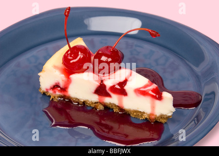 Une tranche de gâteau au fromage aux cerises cerises fraîches avec la sauce aux cerises et un fond rose Banque D'Images