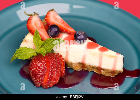 Dessert une tranche de gâteau au fromage aux fraises avec des feuilles de menthe et garnir de sauce garniture aux fraises Banque D'Images