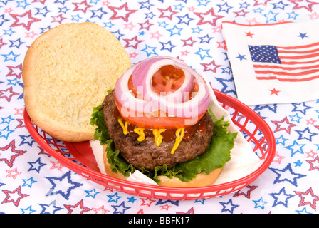 Un hamburger juteux épais dans un panier avec un quatrième thème Juillet Banque D'Images