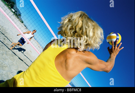 Jouer beach volleball masculin preparing to hit ball Banque D'Images