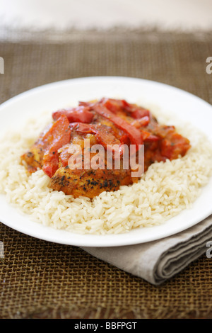 D'authentiques plats préparés Poulet au Curry Rouge Thaï épicé avec des poivrons rouges et riz parfumé isolé sur un fond blanc avec aucun peuple Banque D'Images