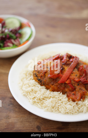 D'authentiques plats préparés Poulet au Curry Rouge Thaï épicé avec des poivrons rouges et riz parfumé isolé sur un fond blanc avec aucun peuple Banque D'Images