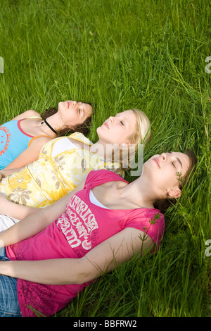 Trois jeunes filles de dormir dans l'herbe Banque D'Images