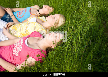 Trois jeunes filles de dormir dans l'herbe Banque D'Images