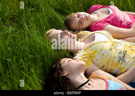 Trois jeunes filles de dormir dans l'herbe Banque D'Images