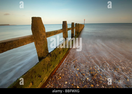 Se précipiter à travers les vagues de la mer en bois sur la défense britannique Devon Dawlish Warren beach Banque D'Images