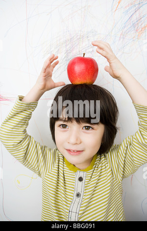 Un garçon avec une pomme sur la tête Banque D'Images