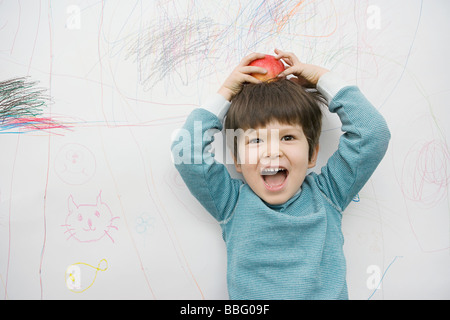 Un garçon avec une pomme sur la tête Banque D'Images