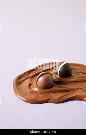 Des chocolats dans du chocolat fondu Banque D'Images