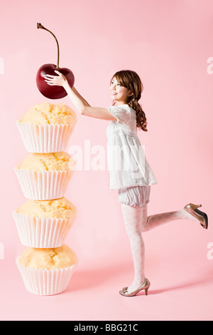 Femme avec cherry and cupcakes Banque D'Images