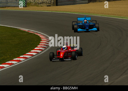 Une des flèches rouges la Formule 1 voiture conduite par Chris Woodhouse dirige un championnat Panoz bleu voiture conduite par Henk De Boer Banque D'Images