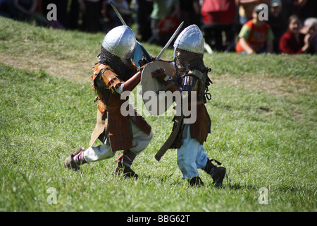 Les enfants jouent lutte avec des épées au cours de la promulgation d'une bataille médiévale au Château Ogrodzieniec, Pologne. Banque D'Images