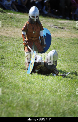 Les enfants jouent lutte avec des épées au cours de la promulgation d'une bataille médiévale au Château Ogrodzieniec, Pologne. Banque D'Images