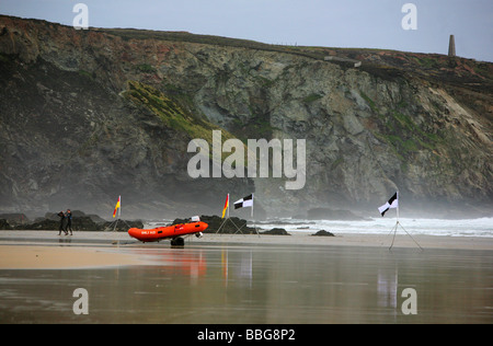 Les surfeurs et canot sur Porthtowan beach, Cornwall, UK Banque D'Images