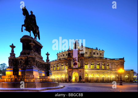 Photo de nuit, l'opéra Semperoper illuminé avec des drapeaux et le roi Jean, statue, place Theaterplatz Dresde, État libre de Saxe Banque D'Images