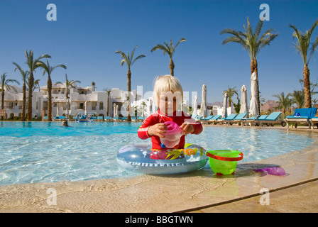 Jeune fille blonde jouant avec des jouets dans une piscine d' Banque D'Images