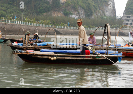 [Eau] taxi, l'homme vietnamiens en petite barque en bois, 'Cat Ba' town Harbour, [la baie d'Halong, Vietnam] Banque D'Images