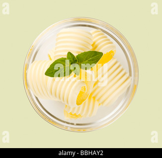 Boucles de beurre dans un bol en verre Banque D'Images