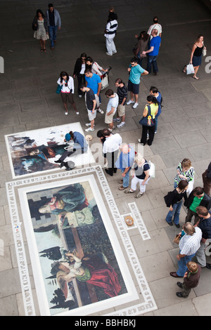 Les touristes admirant Londres le travail d'un peintre de la chaussée rue / Banque D'Images