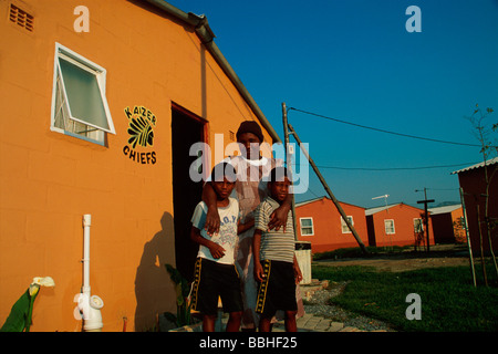 Zenzile Elf et ses deux fils jumeaux se tenir fièrement devant leur nouveau home dans Fatyela Square Zenzile a déployé de grands efforts pour assurer Banque D'Images