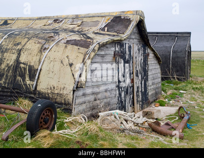 Old weathered wooden les hangars à bateaux sur la plage à Lindisfarne Bay, Île Sainte North East England UK Banque D'Images