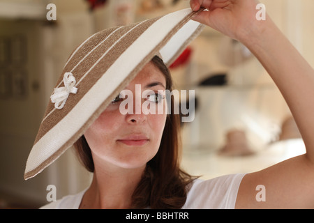 Une femme essaie sur un designer hat in hat shop James Lock & Co Numéro 6 St James's Street, Londres Banque D'Images