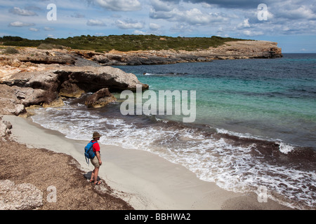 Woman backpacker beach sur la côte à Cala s'Algar Majorque Espagne Banque D'Images