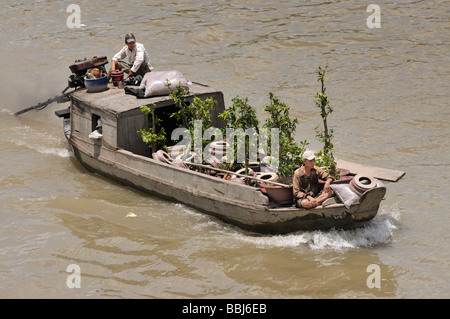 Deux hommes sur un bateau en bois sur le fleuve Mekong, négociant des plantes, Can Tho, Delta du Mékong, Vietnam Banque D'Images