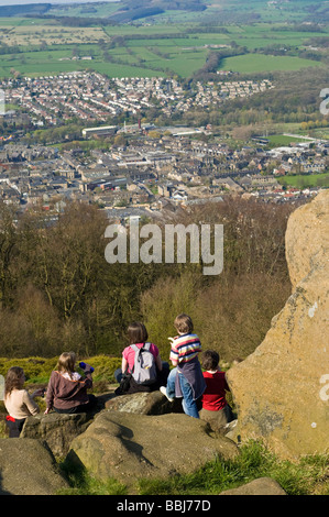 Dh Grand Ouest Dib CHEVIN WEST YORKSHIRE Family sitting on rock crag rocheux dominant Otley forest park vue sur colline Banque D'Images