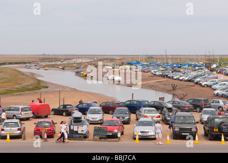 Le parking principal à Blakeney Point en Blakeney North Norfolk uk plein de voitures et montrant des bateaux à voile à l'arrière-plan Banque D'Images