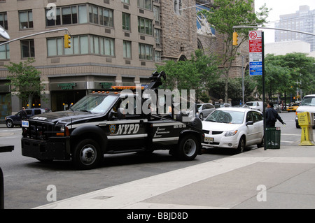 Stationnement en infraction le NYPD remorquer le chariot et policière de la tentative d'entrer dans la voiture, New York USA Banque D'Images