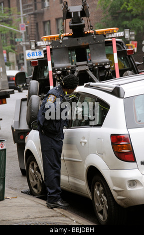 Remorquer le chariot avec NYPD police femmes essayant d'avoir accès à la voiture à l'aide d'un long morceau de fil épais Manhattan NEW YORK USA Banque D'Images