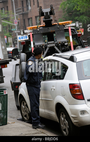 Remorquer le chariot avec NYPD police femmes essayant d'avoir accès à la voiture à l'aide d'un long morceau de fil épais Manhattan NEW YORK USA Banque D'Images