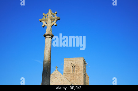 Partie supérieure du monument aux morts et Église de Saint Pierre à grand Walsingham, Norfolk, Royaume-Uni, contre un ciel bleu. Banque D'Images