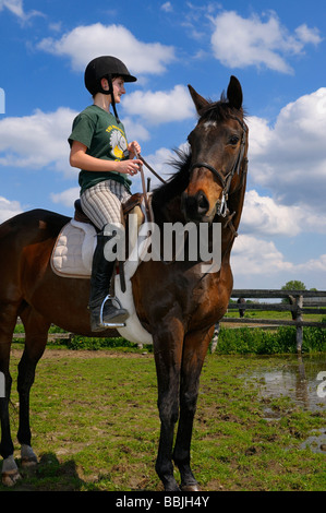 Teenage girl posant son pur-sang de cheval dans un corral après une randonnée en ontario Banque D'Images