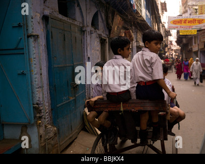 Les garçons à l'école tiré derrière un vélo en Inde Banque D'Images