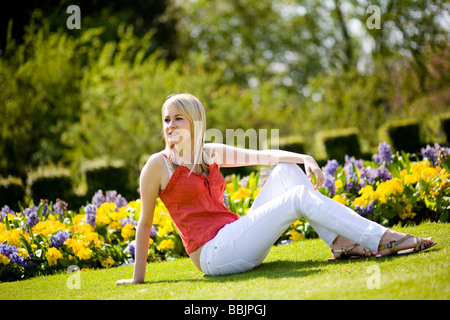 Une jeune femme est assise dans le parc et bénéficie de l'été chaud. Banque D'Images