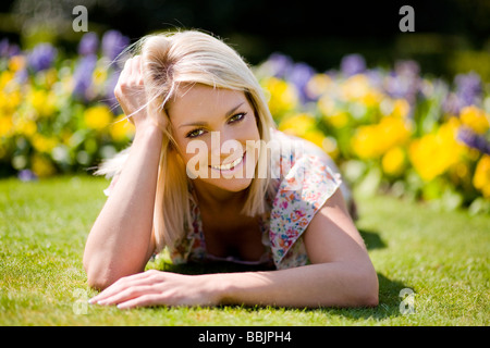 Une jeune femme profitant du beau temps dans un parc. Banque D'Images