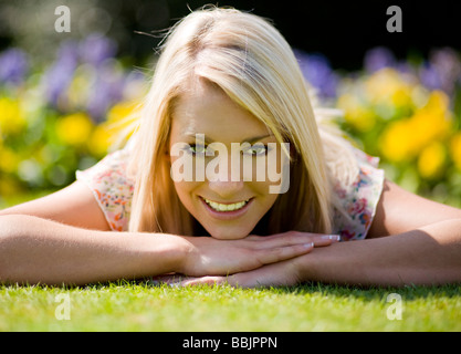 Une jeune femme profitant du beau temps dans un parc. Banque D'Images