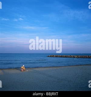 Femme seule assise sur la plage en face de la mer. La mer Méditerranée. La France. Banque D'Images