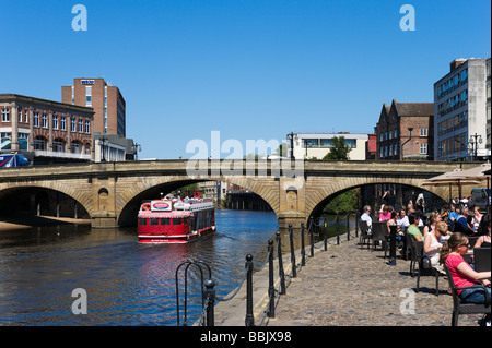 Excursion en bateau passant sous Ouse Bridge près d'un pub sur King's Staith, York, North Yorkshire, Angleterre Banque D'Images