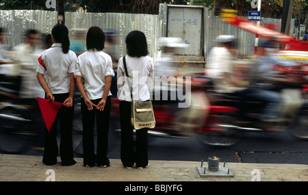 Croisement des patrouilleurs de service prêt à aider les touristes à traverser les routes achalandées à Ho Chi Minh City Vietnam Banque D'Images